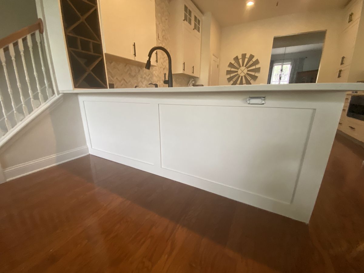 White kitchen island with quartz top over hardwood floors
