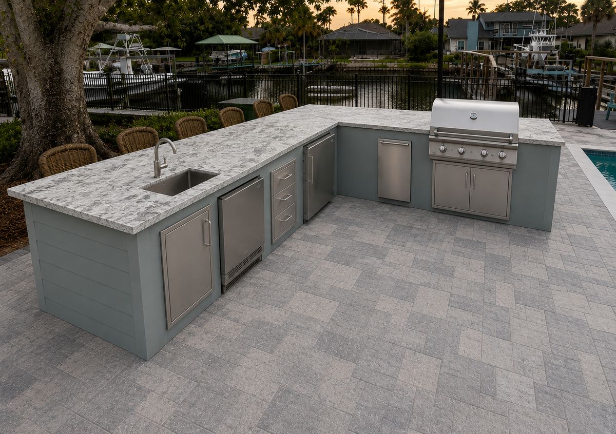 Gray outdoor kitchen with grill and granite counters by a pool